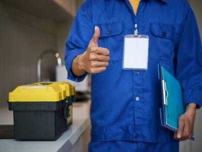 Cropped image of repaiman with tool box showing thumbs-up